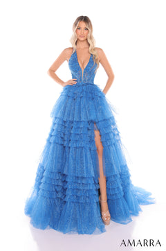 A woman wears a tiered, sparkly peacock blue ball gown with a plunging neckline and high leg slit by Amarra.