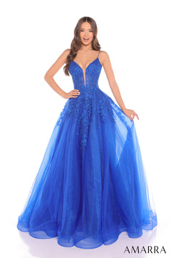 A woman wears a long Royal Blue tulle ballgown with an embellished bodice and spaghetti straps.