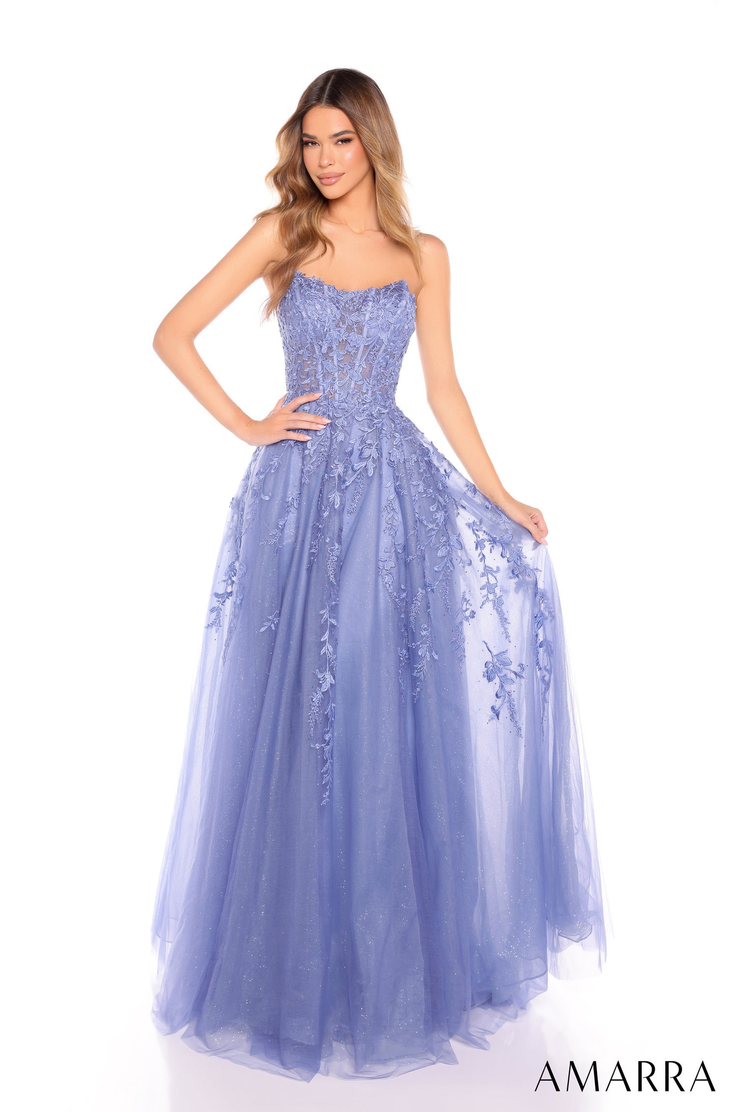 A model wears a strapless, full-length Slate Blue ballgown with intricate lace and tulle detailing.