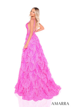 A woman wears a full-length, bright pink lace ballgown with a fitted bodice and voluminous tiered skirt.