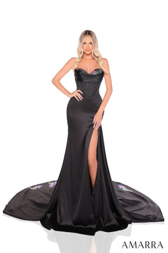 A model wears a black strapless evening gown with a dramatic train and high slit by Amarra.