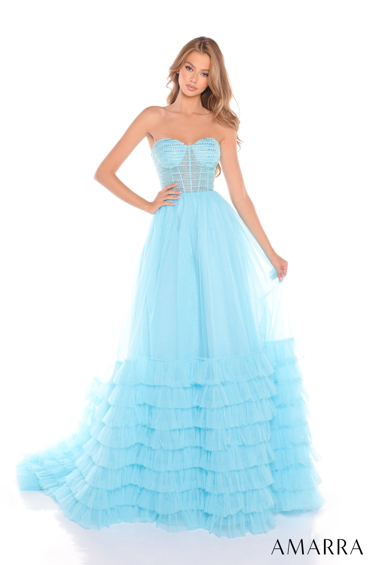 A strapless light blue ball gown with a corset bodice and tiered ruffled skirt on a fashion model.