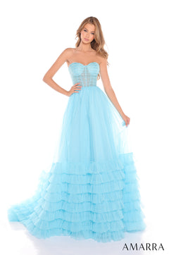 A strapless light blue ball gown with a corset bodice and tiered ruffled skirt on a fashion model.