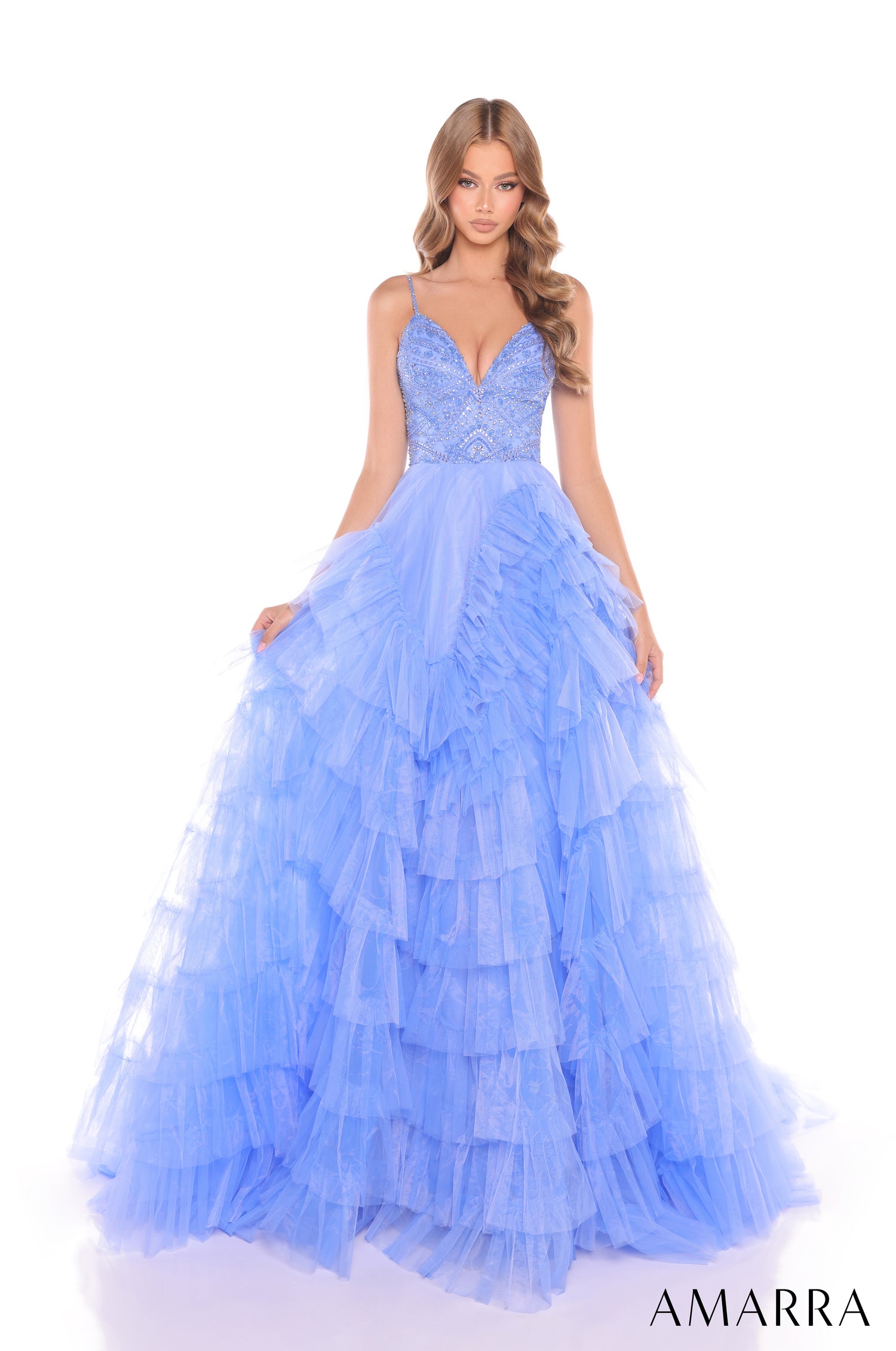 A model wears a periwinkle tiered tulle ball gown with a beaded bodice and spaghetti straps by Amarra.