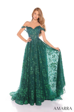 A model wears a sparkling emerald off-shoulder ball gown with floral lace and a sweeping full skirt.