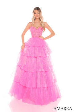 A model wears a tiered, Hot Pink tulle ball gown with a corset-style bodice and sweeping skirt.