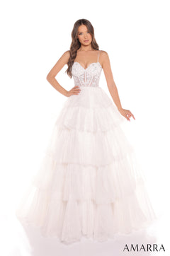 A woman wears a tiered, floor-length ivory wedding gown with a beaded corset bodice and thin straps.