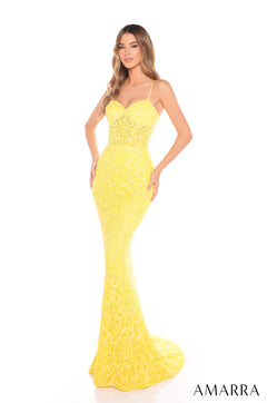 A woman in a form-fitting, sequined yellow gown with spaghetti straps stands against a white background.