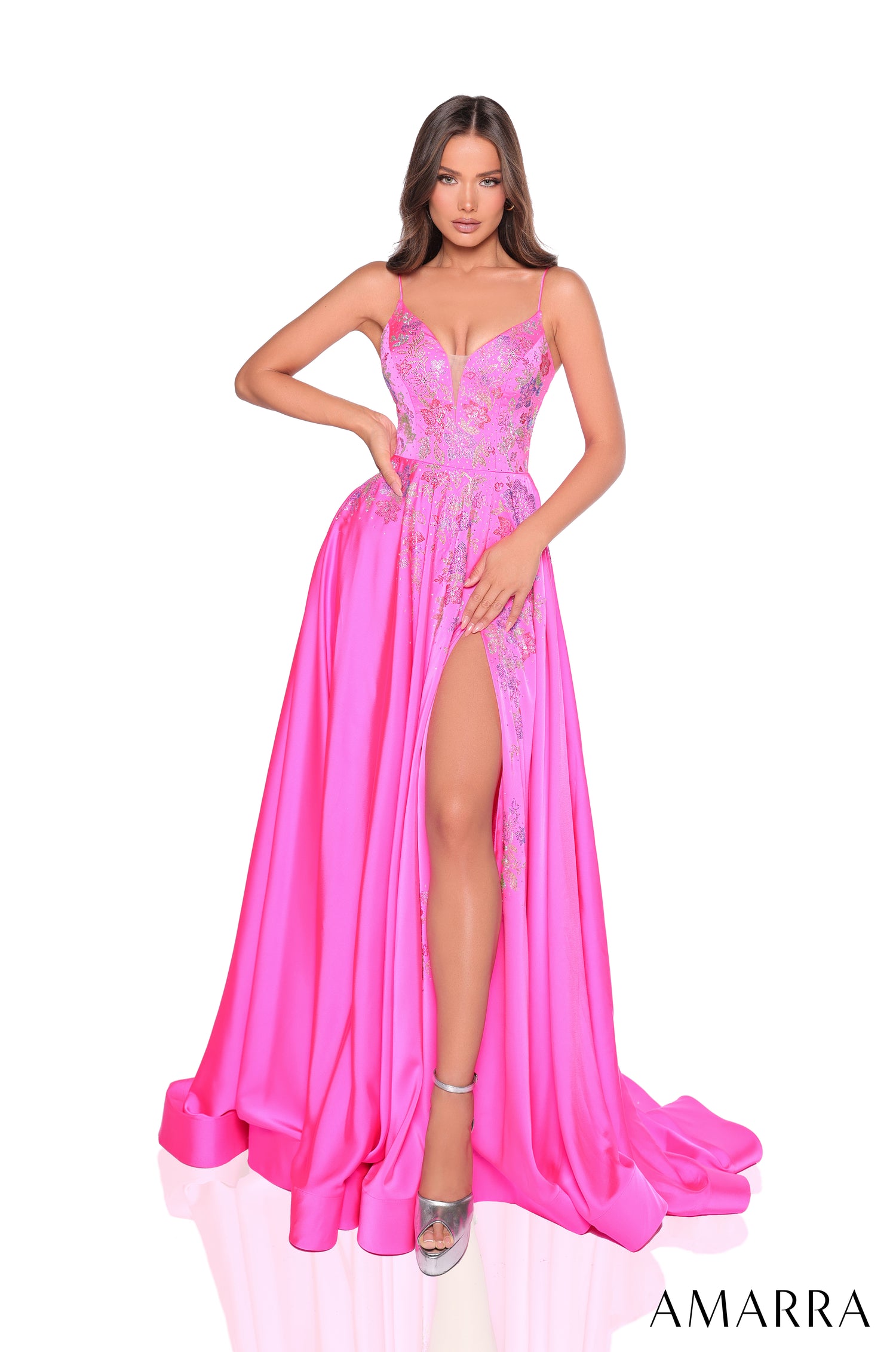 A model wears a fuchsia lace evening gown with a thigh-high slit and silver shoes.