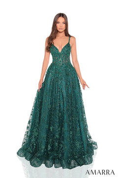 A woman wears a sparkling emerald ball gown with a plunging neckline and full, glittery tulle skirt.