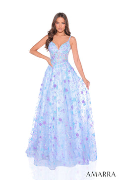 A model wears a flowing Light Blue/Lilac floral ball gown with spaghetti straps and an embellished bodice.