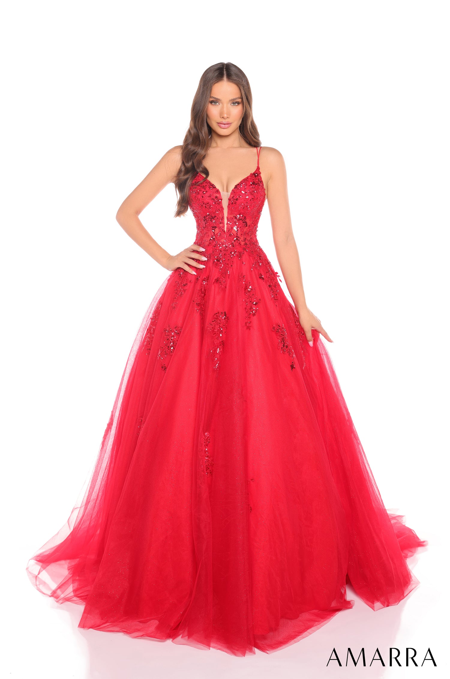 A model wears a full, red ball gown with sequined bodice and tulle skirt from Amarra.