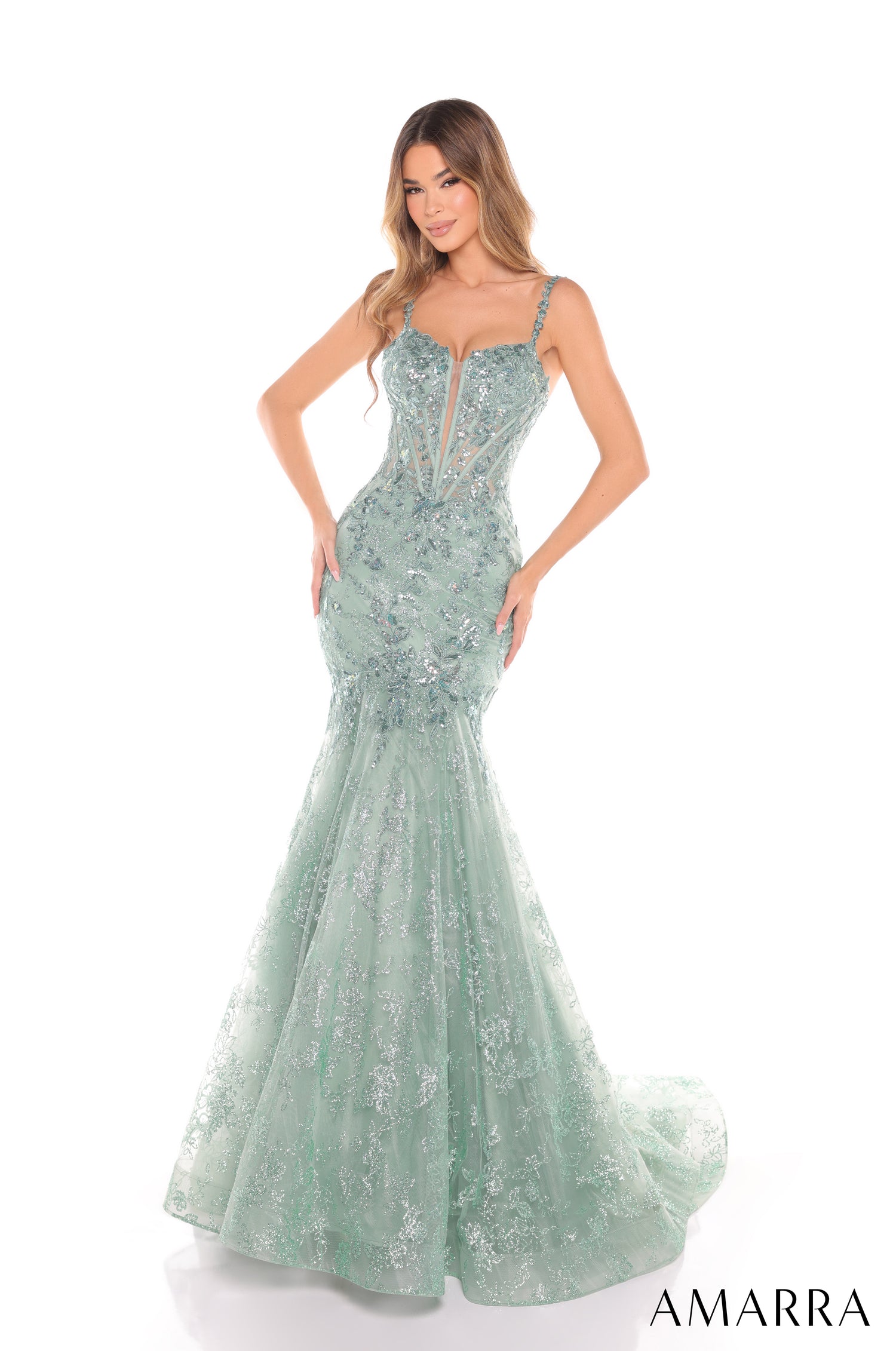 A model wears a sage green sequined mermaid gown with a fitted bodice and flowing tulle skirt.