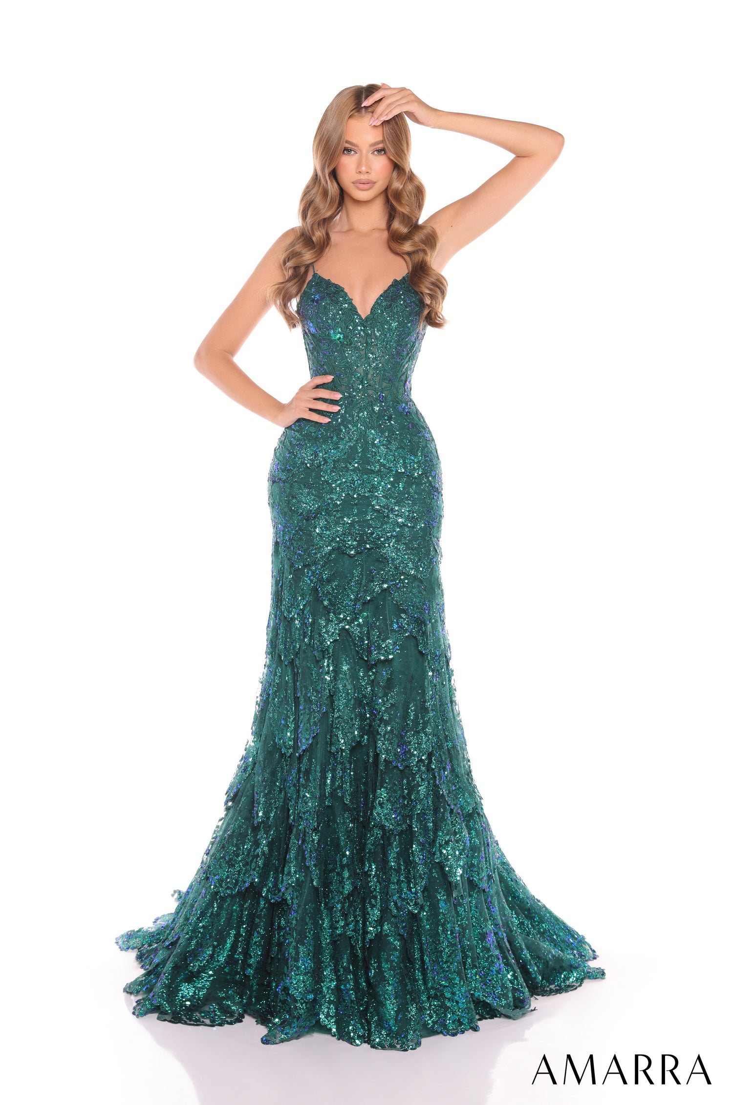 A model wears a long, form-fitting emerald sequin gown with a sweetheart neckline and full-length train.