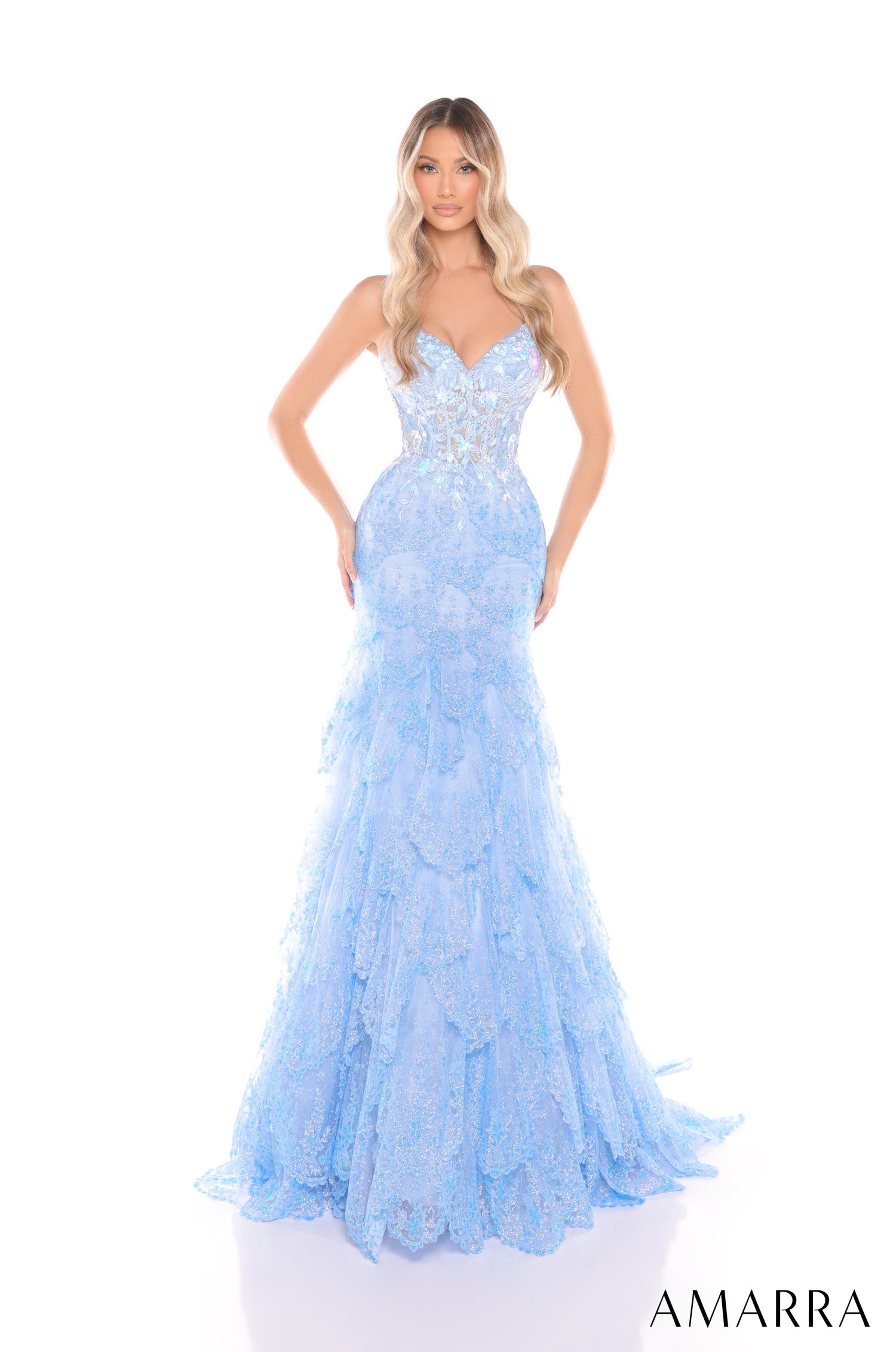 A woman wears a light blue, strapless, mermaid-style evening gown with intricate lace and a fitted bodice.