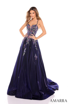 A model wears a navy blue floral ballgown with a fitted bodice and sweeping skirt by Amarra.