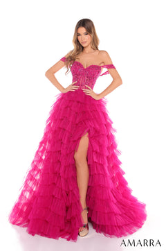 Model wears a dramatic off-shoulder bright fuchsia tiered tulle gown with a thigh-high slit and embellished bodice.