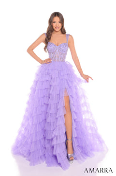 A model wears a tiered Lilac/Electric Orchid tulle ball gown with a corseted bodice and high leg slit.