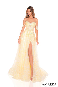 A model wears a light yellow off-shoulder gown with lace details and a high side slit.