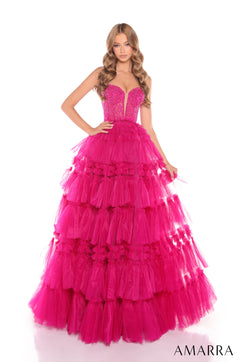 A woman wears a tiered, full-length ball gown in bright fuchsia tulle with a beaded sweetheart bodice.