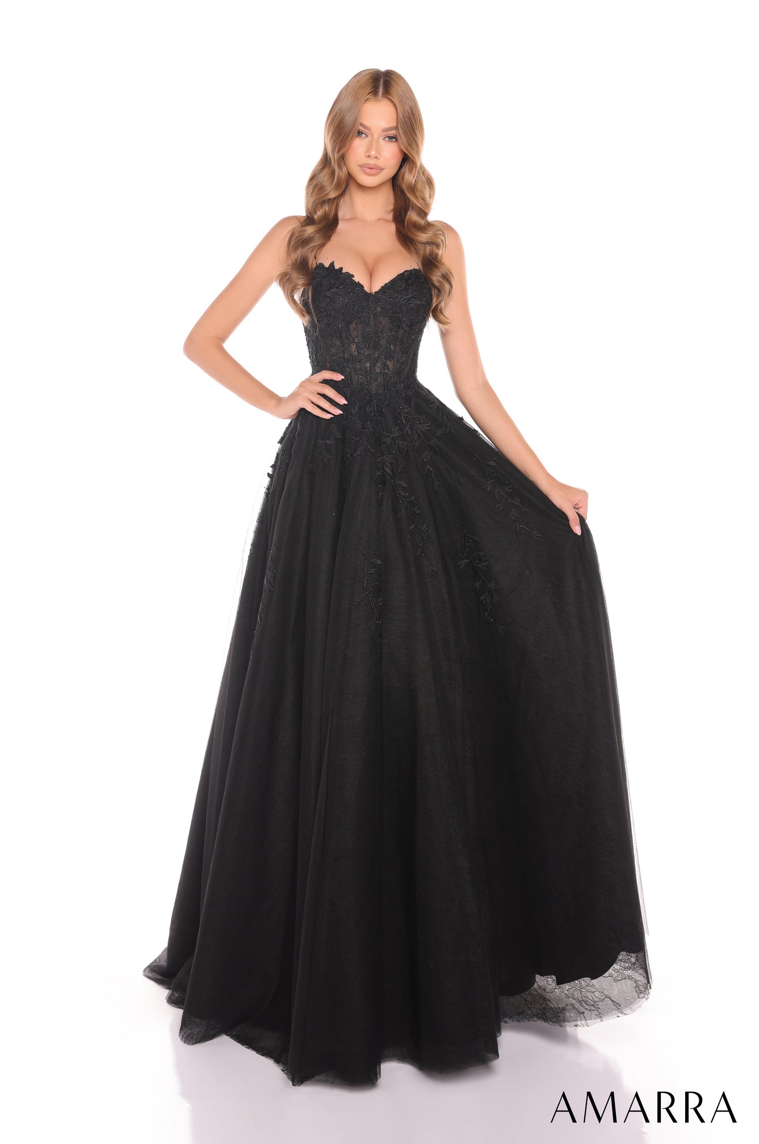 A floor-length black ball gown with a sweetheart bodice and full tulle skirt, styled on a model.
