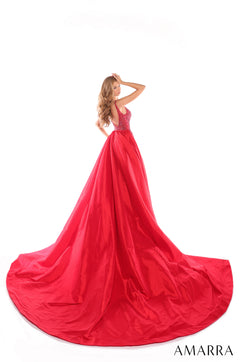 A woman wears a vibrant red ballgown with a beaded bodice and sweeping, voluminous skirt on a white background.
