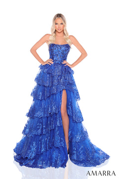 A royal blue tiered ball gown with sequins and a high slit, modeled on a white background.