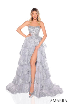 A strapless, tiered silver gown with sparkling sequins and a high leg slit, worn by a model in matching heels.