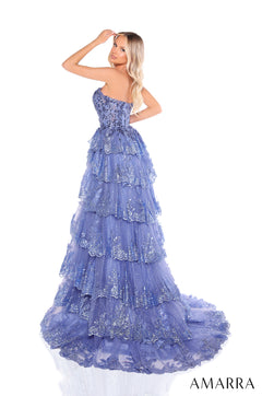 A blue tiered, sequined gown with a strapless bodice and dramatic ruffled skirt worn by a blonde model.