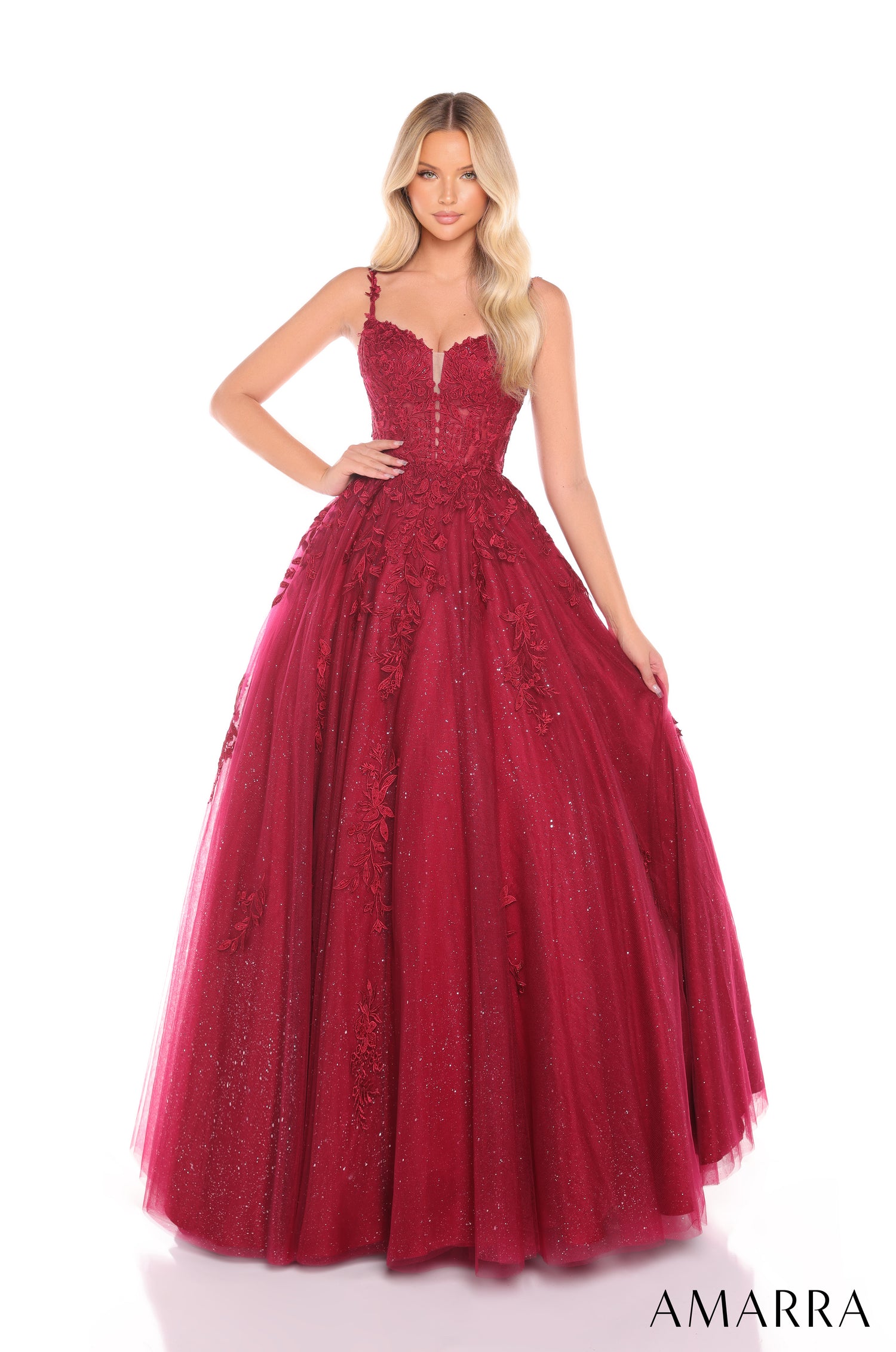 A floor-length wine ballgown with floral appliqués and a sweetheart neckline, photographed on a model with blonde waves.