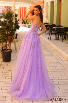 A woman in a flowing lavender ball gown with floral embellishments stands on a brick pathway.