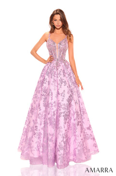 A model wears a lilac ball gown with floral lace detailing and a corseted bodice.