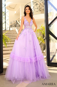 Model wears a lilac ball gown with sequined bodice and tiered tulle skirt, standing on a tiled floor near a staircase.