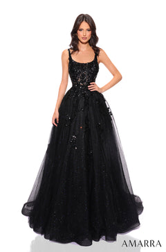A woman wears a floor-length, Black, sequined ball gown with a fitted bodice and tulle skirt by Amarra.