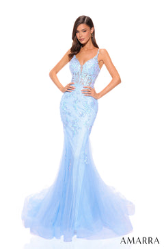 A slender model wears a light blue mermaid-style evening gown with intricate lace and sheer tulle detailing.