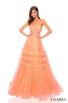 A model wears a full-length, tiered neon orange tulle gown with a strapless corset-style bodice.