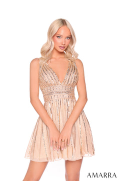 A blonde model wears a short, gold sequined cocktail dress with a plunging neckline and flared skirt.