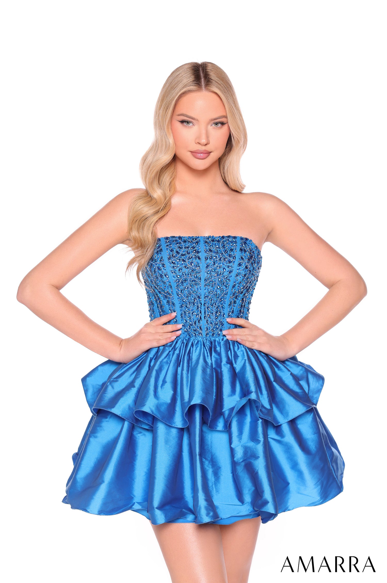 A model wears a strapless, sequined Peacock blue cocktail dress with a tiered, ruffled skirt.