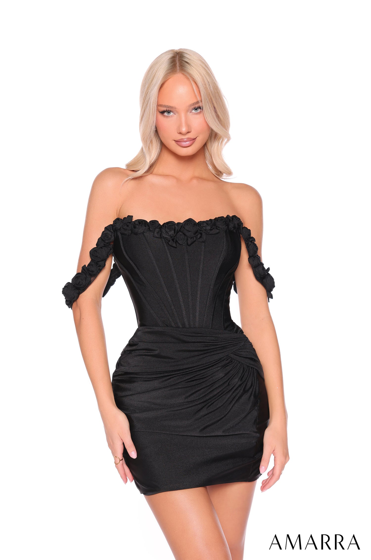 A model wears a strapless, ruched Black mini dress with off-shoulder details by Amarra.