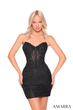 A blonde model wears a strapless, form-fitting black lace corset dress with an embellished bodice.