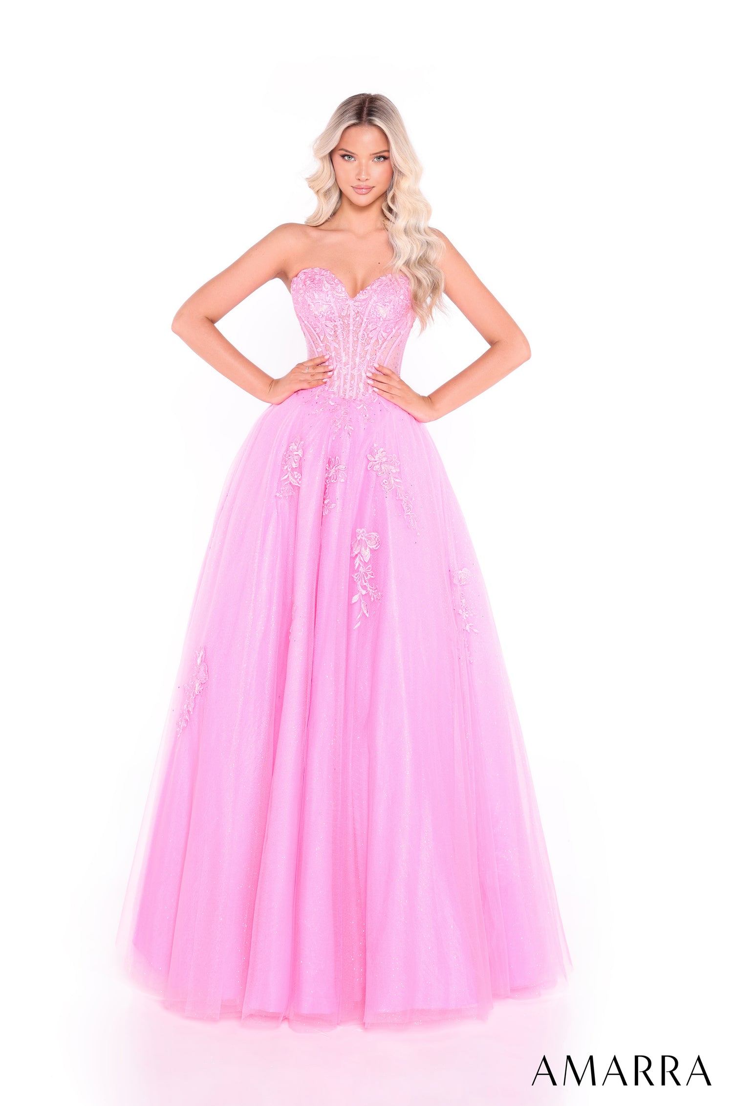 A woman wears a strapless, boned Bright Pink ballgown with an embellished bodice and full tulle skirt.