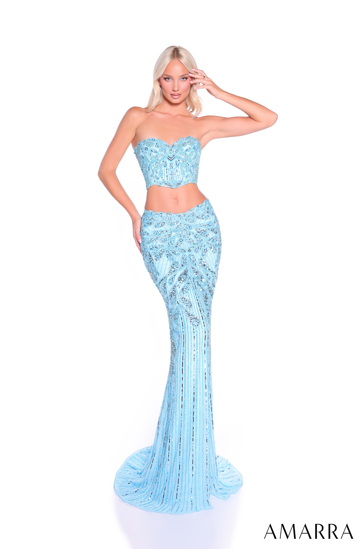 A model wears a strapless, light blue sequined two-piece gown with a fitted mermaid skirt.