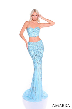 A model wears a strapless, light blue sequined two-piece gown with a fitted mermaid skirt.