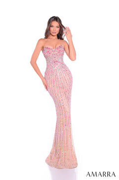 A strapless mermaid gown in Nude/Fuchsia/Candy Pink, covered in sparkling sequins and crystals, hugs the model's silhouette.
