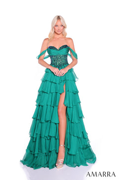 A model wears a strapless emerald tiered gown with sequined bodice and dramatic high leg slit.