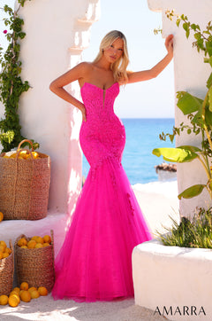 A model wears a strapless fuchsia mermaid gown with lace details near a beach with lemons in baskets.