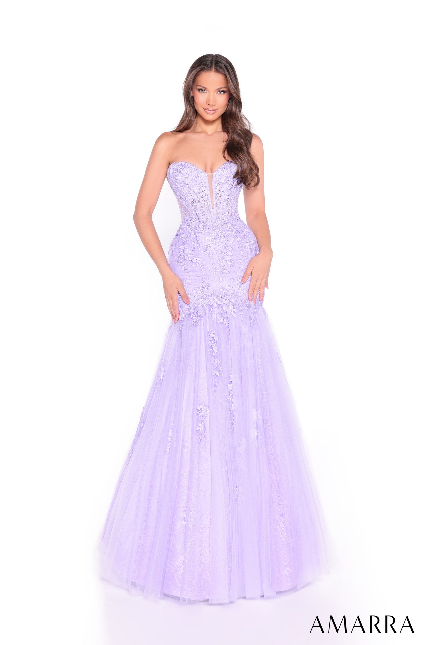 A model wears a strapless lilac mermaid-style gown with intricate lace and tulle details.