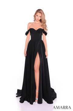 A woman wears a black off-shoulder gown with a high slit and ruffled sleeves, standing on a white background.