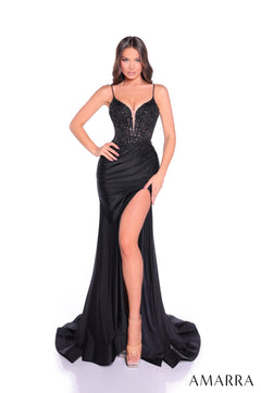A model wears a black sequined evening gown with a thigh-high slit and dramatic train.