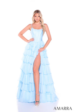 A woman wears a light blue tiered ruffle gown with a thigh-high slit and spaghetti straps.